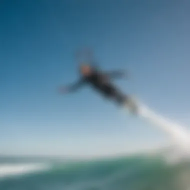 Mastering Kitesurfing Techniques A skilled kitesurfer performing a jump, illustrating advanced techniques in action against a clear blue sky.