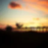 A kiteboarder catching air against a vibrant sunset at Lake Worth Pier