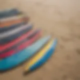 A collection of diverse used kite boards displayed on a beach