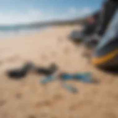 A close-up of essential kite surfing gear laid out on the sandy beach