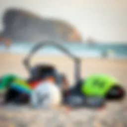 A variety of kiteboarding gear displayed on a sandy beach.