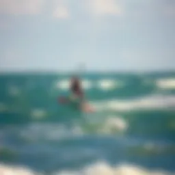 A kiteboarder gliding over the waves with clear weather conditions