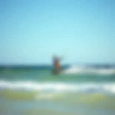 Kiteboarder riding the waves with a backdrop of a clear sky