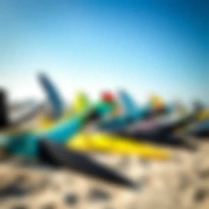 A variety of kitesurfing kites laid out on a sandy beach