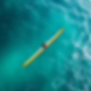 An aerial view of a wingfoiler gliding over clear turquoise waters