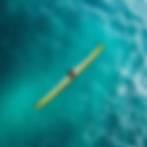 An aerial view of a wingfoiler gliding over clear turquoise waters
