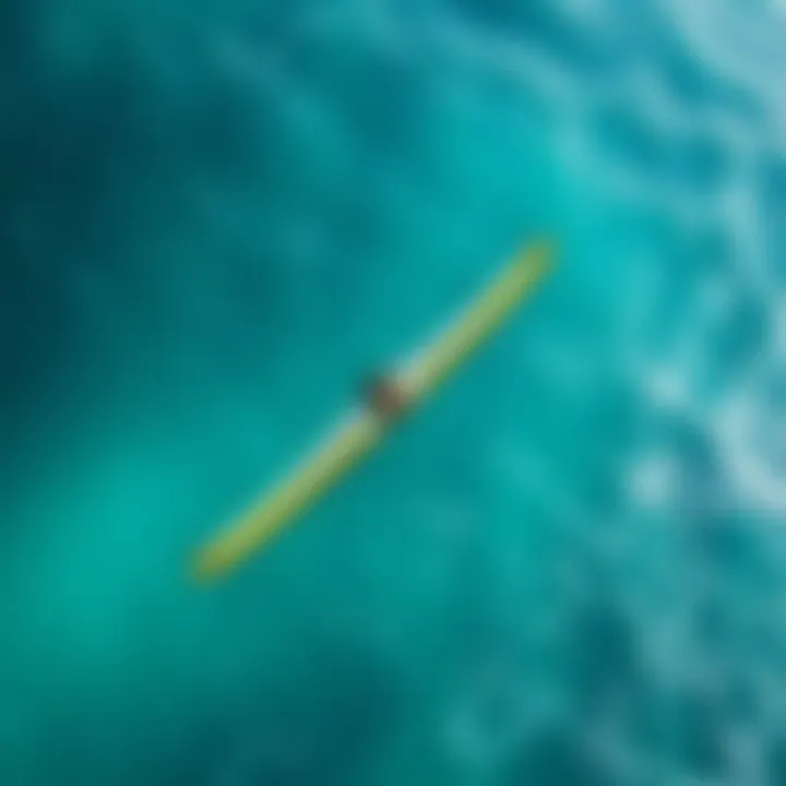 An aerial view of a wingfoiler gliding over clear turquoise waters
